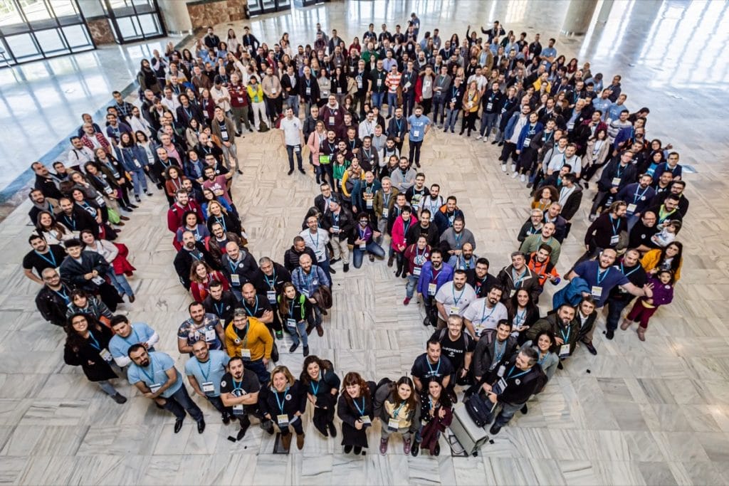 asistentes a una WordCamp forman el logo de WordPress visto desde arriba